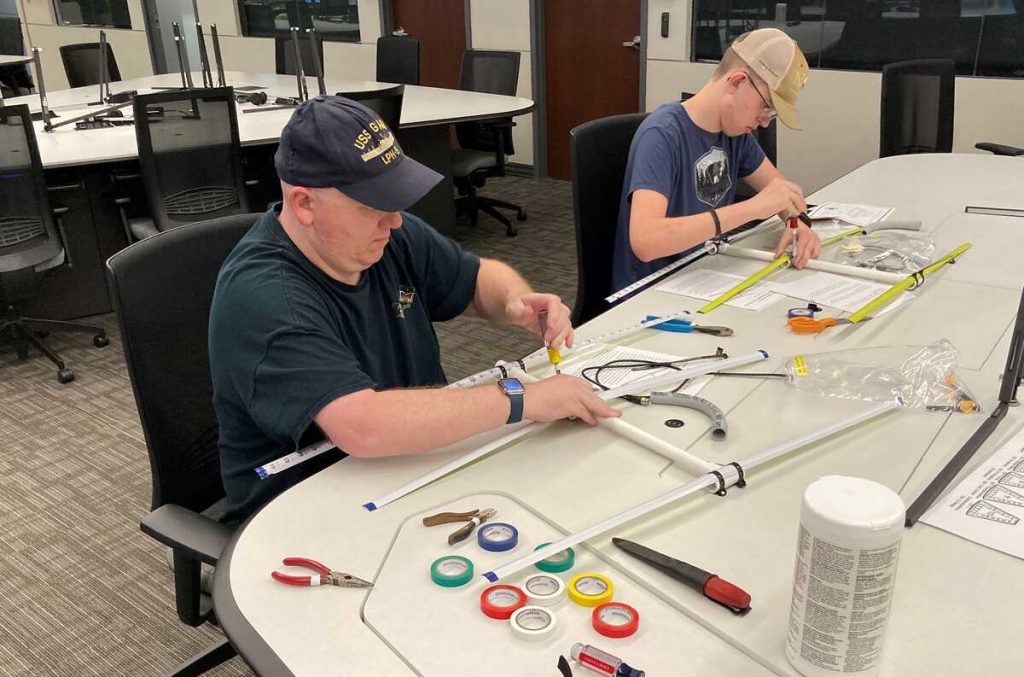 Doug and Nick building their tape measure Yagis. [Dave, KI4PSR]